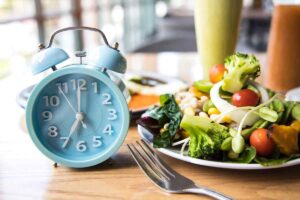 Piatto di insalata vicino a una forchetta e a un orologio