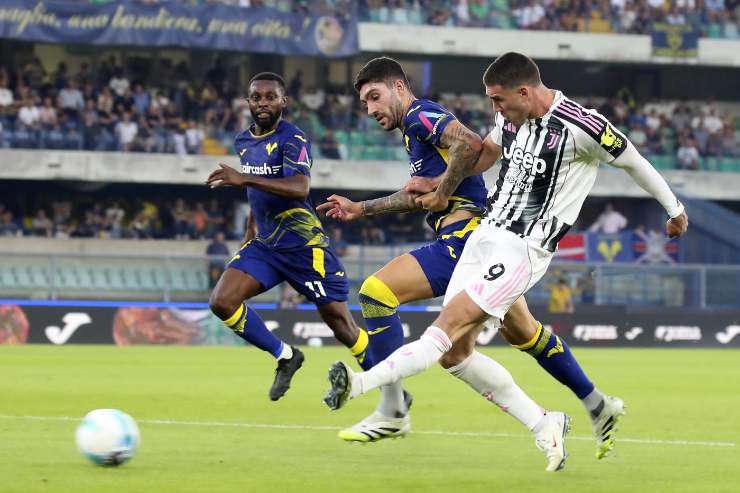 Vlahovic al tiro contrastato da un avversario